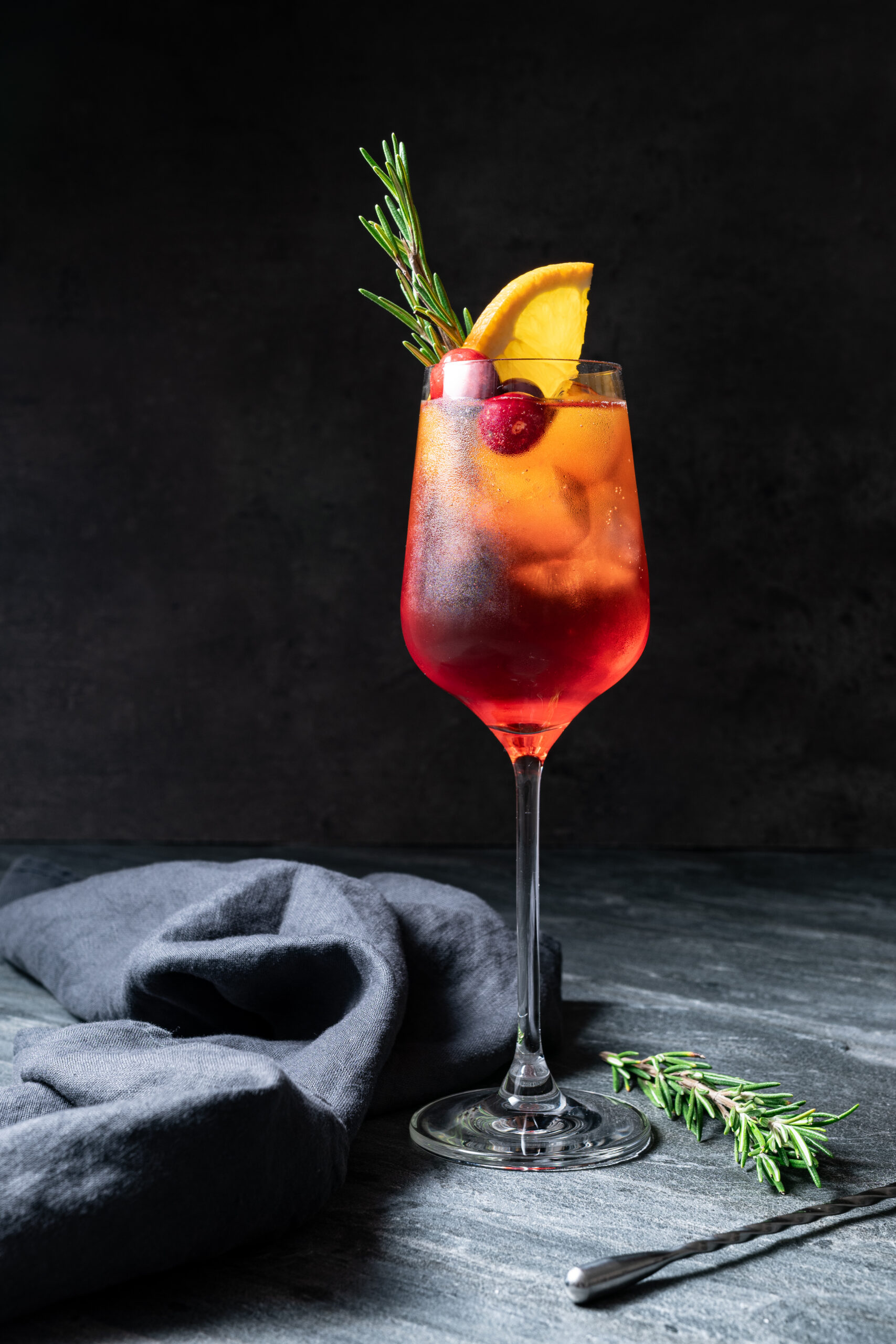 Cranberry Aperol Spritz in a glass shot from the side