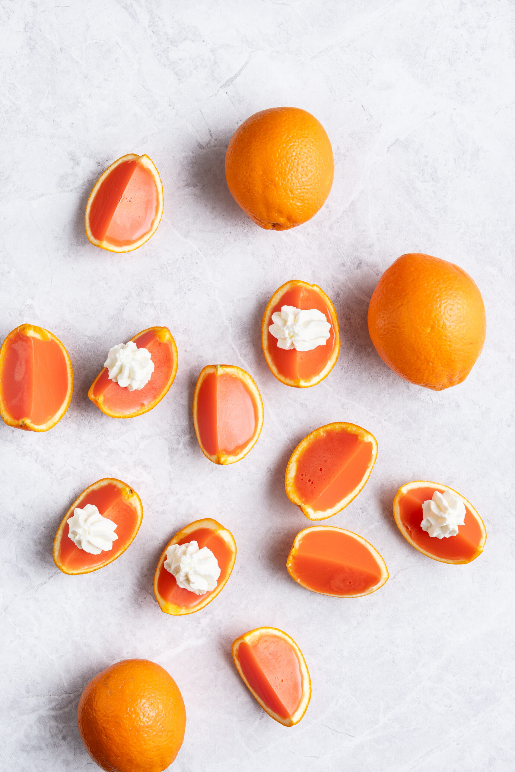 Orange creamsicle Jell-O shots on a table shot from above