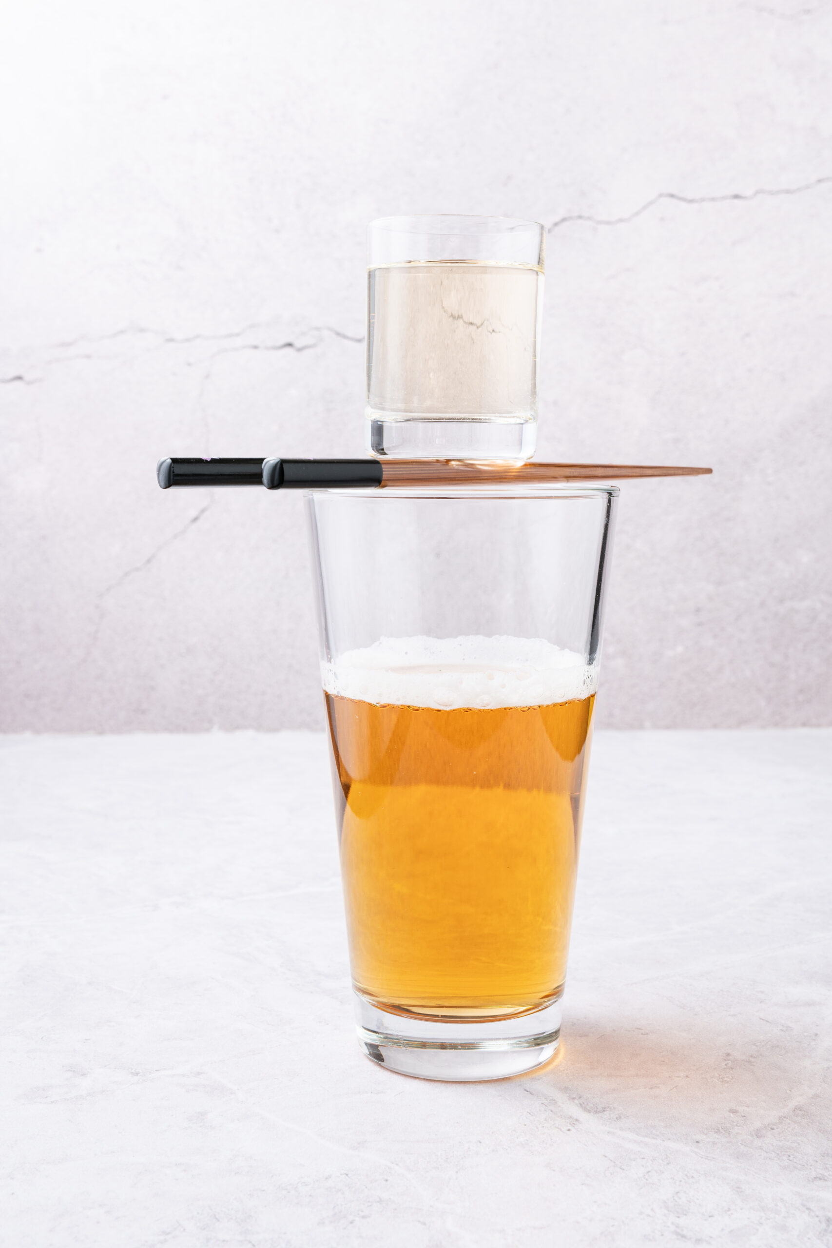 Sake Bomb Recipe - sake shot over a beer glass shot from the side