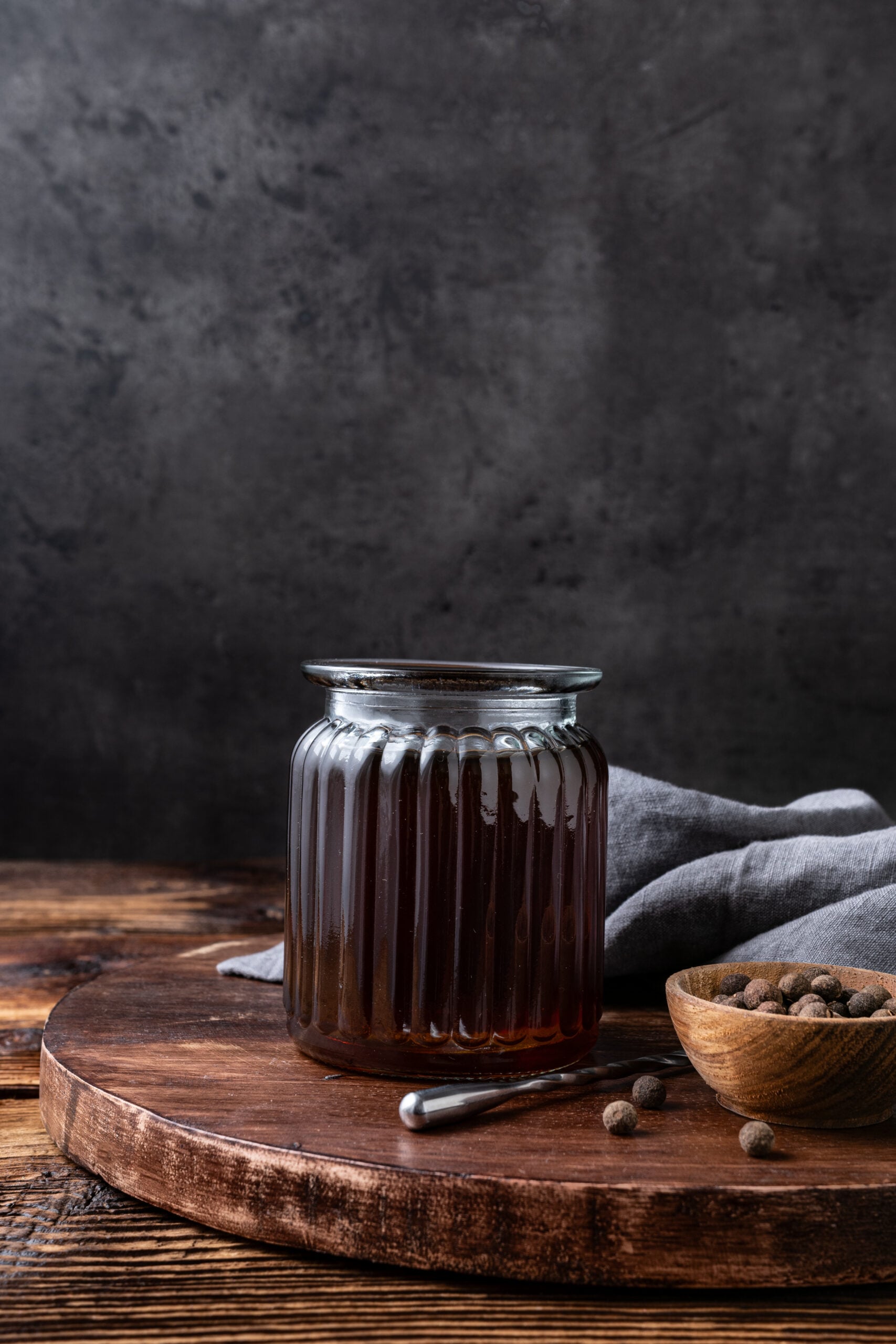 Allspice Dram in a bottle on a tray shot from the side