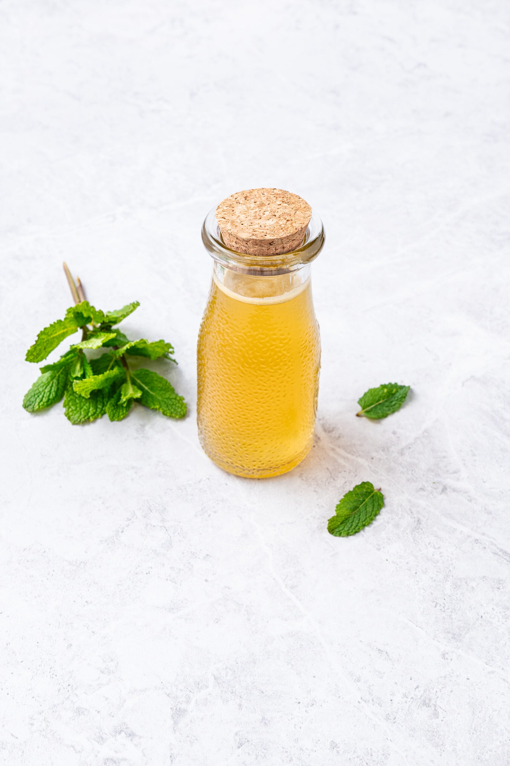 Mint Simple Syrup in a glass bottle shot from the side