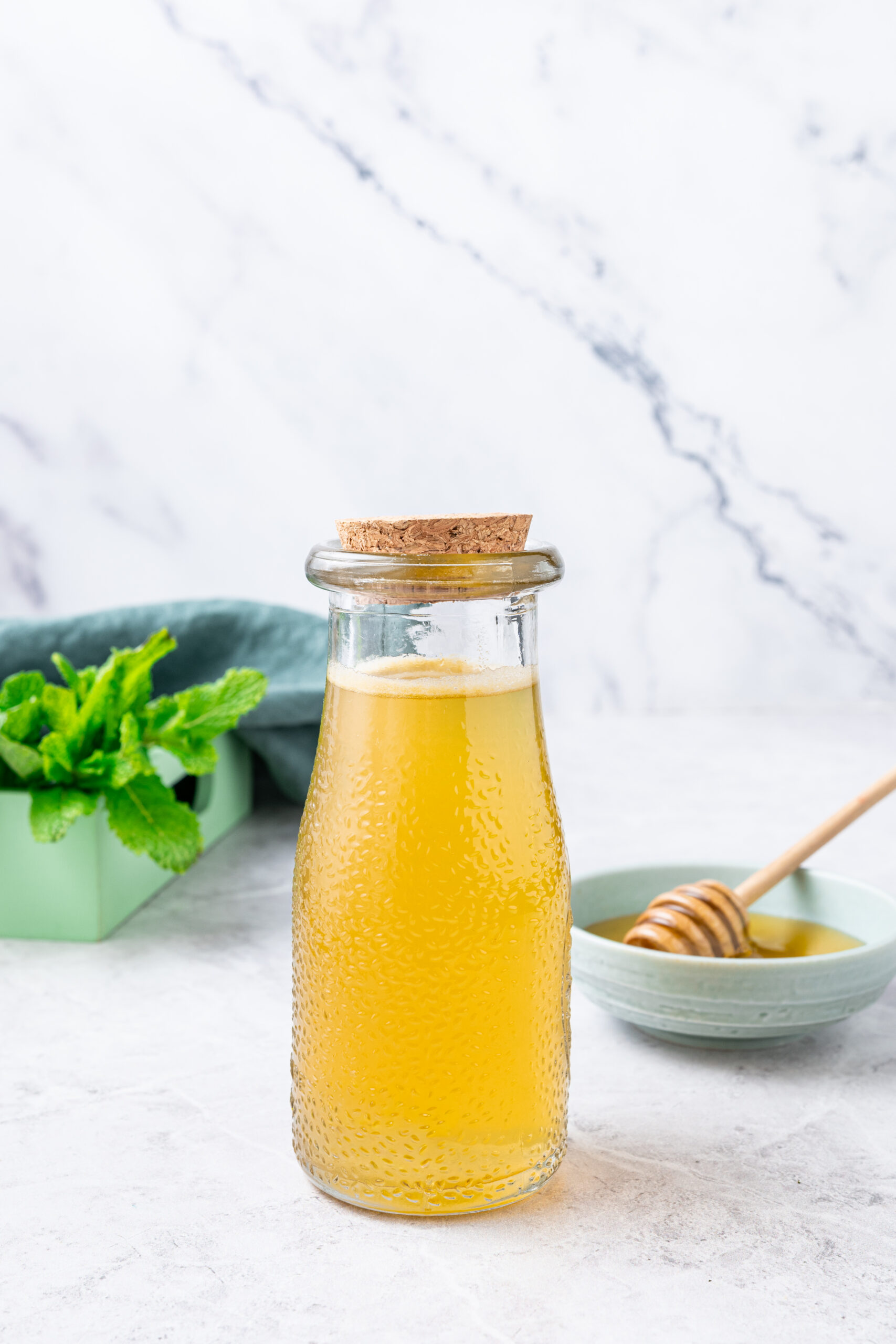 Mint Simple Syrup in a glass bottle shot from the side